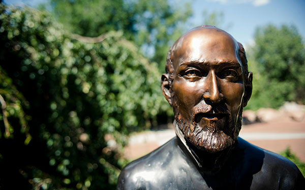 Closeup view of the face of a bronze statue of St. Ignatius of Loyola on the Northwest Denver campus