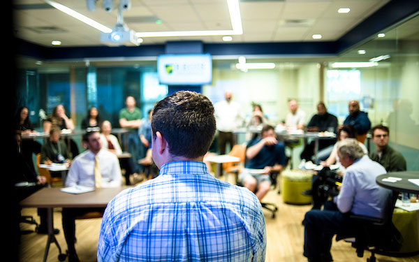 a large crowd gathered in the Innovation Center Incubator in Regis University's Anderson College of Business and Computing