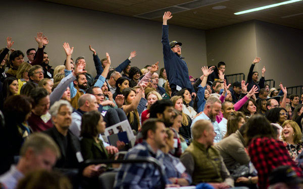 crowd raising hands in excitement