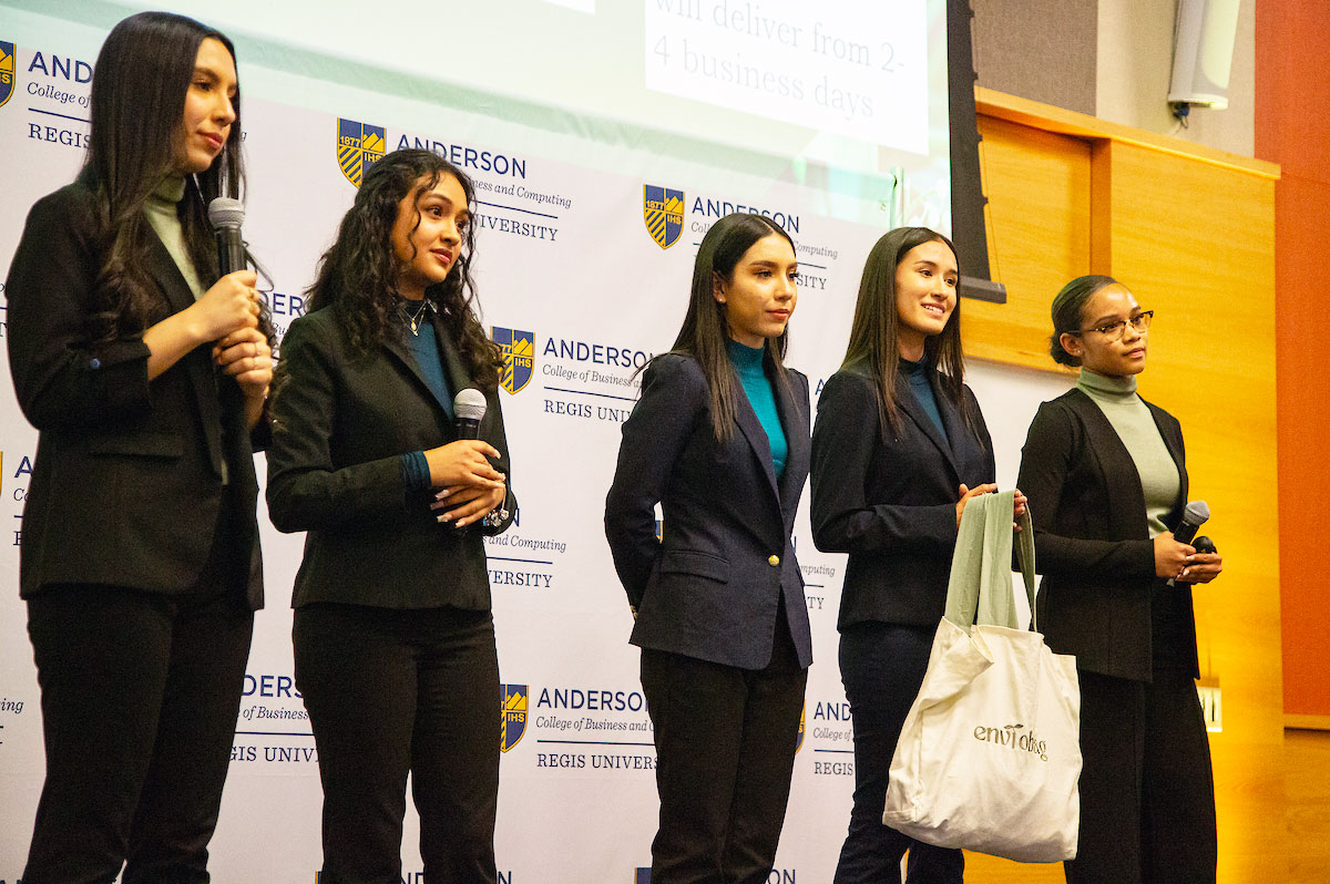 A team of five students presents their business idea at a competition hosted by the Anderson College of Business and Computing at Regis University.