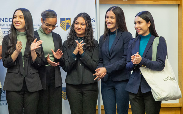 Five students stand together with professional attire on