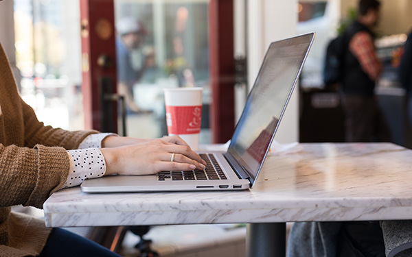 Student working in a coffee shop on her computer