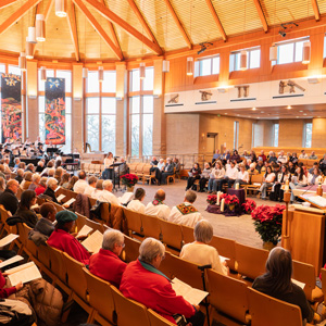 Regis University community gathered in a chapel for a service with a choir