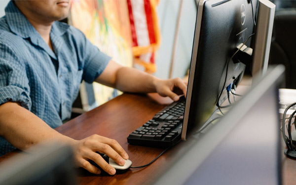 man on desktop computer moving mouse