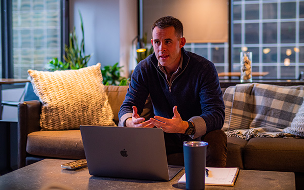 professional man sitting on a sofa talks to a laptop