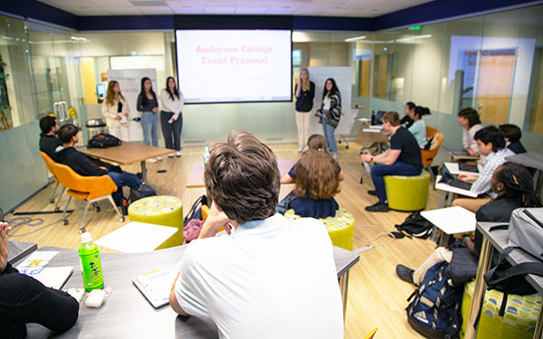 students in a marketing class listen intently while their classmates make a presentation in the Gronowski Innovation Lab
