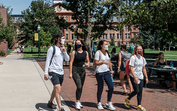 Masked students walk on campus