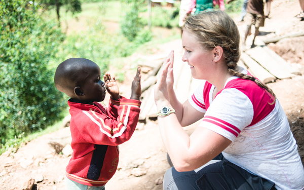 Regis University student high-fiving a child during a Service Oriented Field Experience