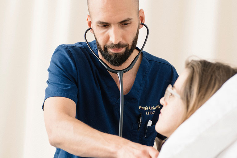 nursing student examines another nursing student with a stethoscope in the simulation lab