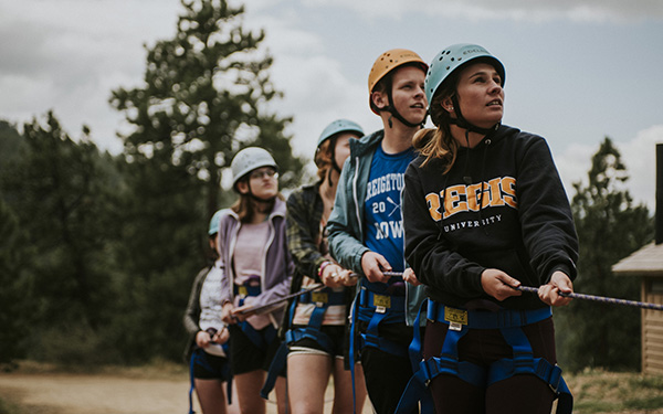 Students doing teamwork climbing activity