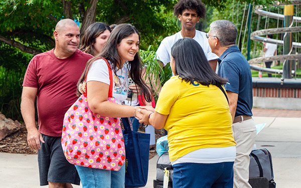 President Salvador Aceves and Dean of Students Erica Ingalls shake hands with a new student and their family as the welcome them to campus on move-in day 