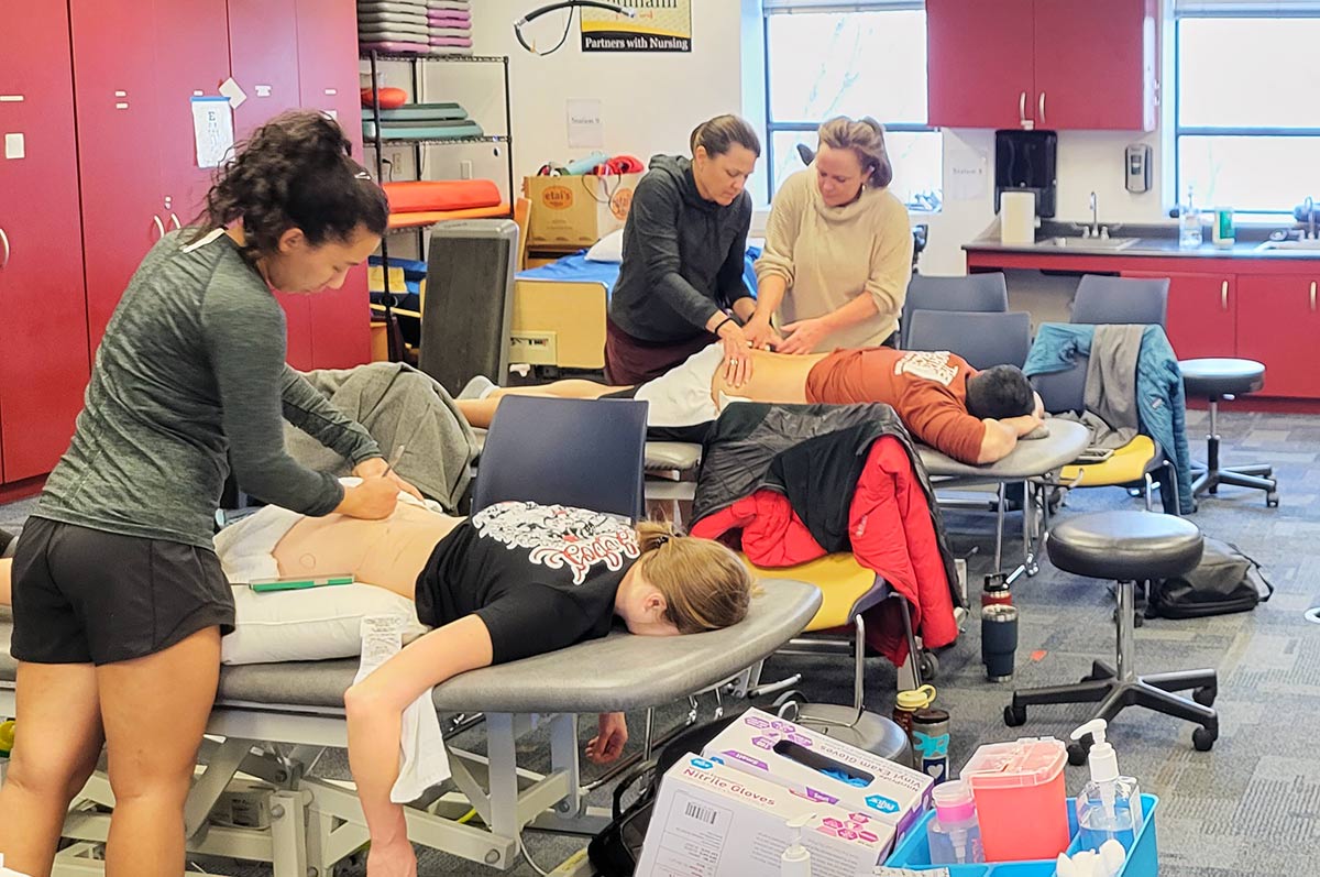 Residency students practice dry needling with faculty guidance in the PT lab