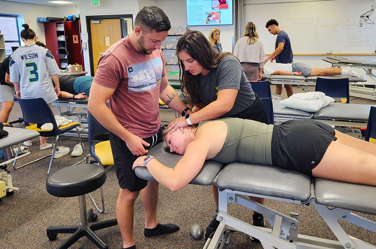 pairs of residency students work on their classmates in the PT lab on the Regis campus