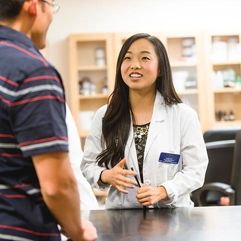 Pharmacist at desk helping customer