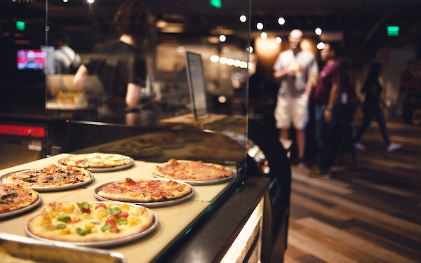 pizzas for sale in Walker's Pub with diners in the background