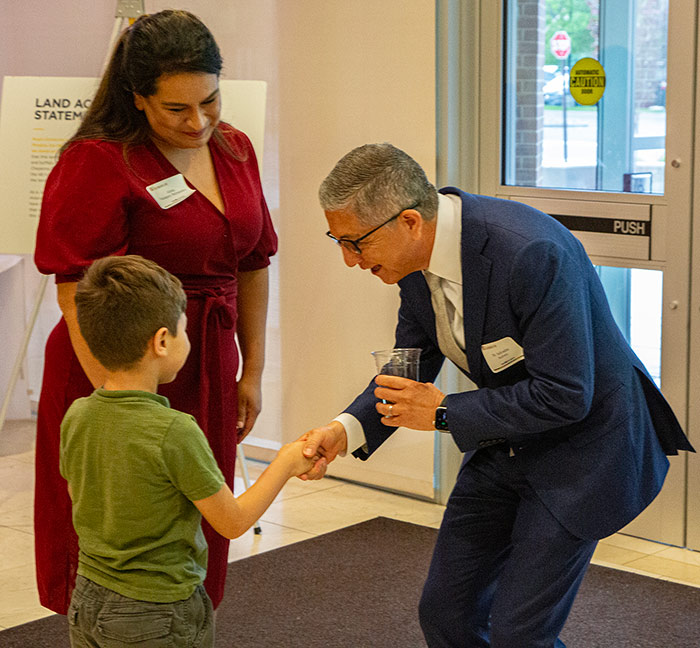 president aceves shanking young students hand