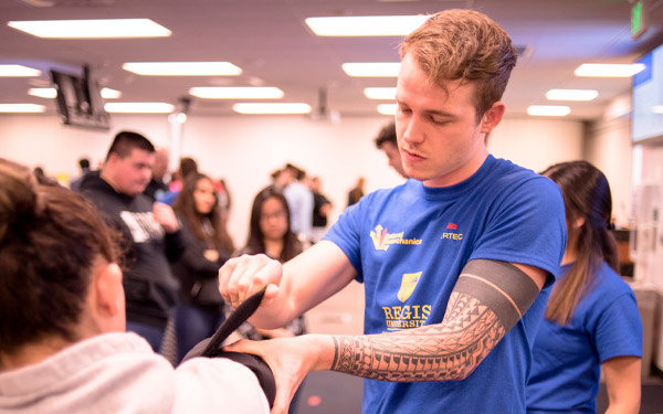 physical therapy student checks patient's blood pressure with cuff