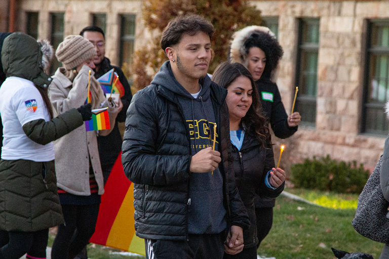 Students participating in a candlelight event supporting the LGBTQ+ community on campus.