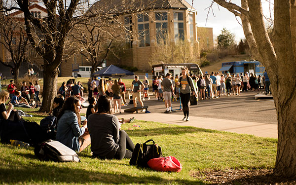 students sit outside during student event