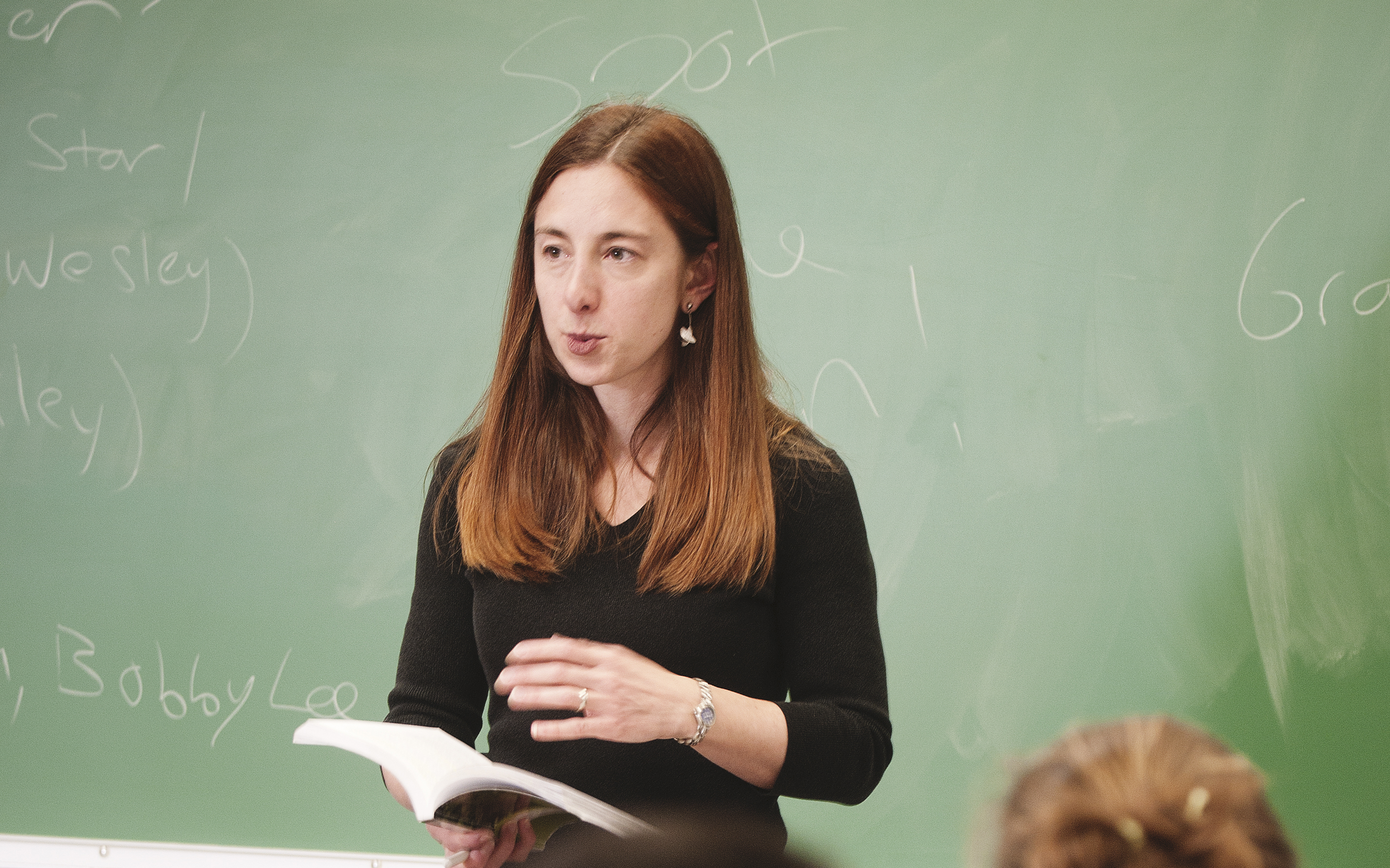 Teacher holds book and talking