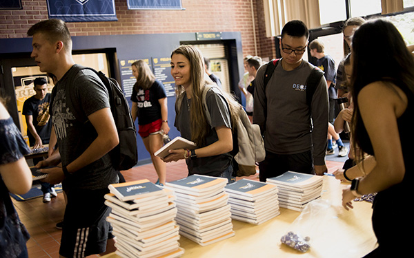 students stand in line and collect first-year books