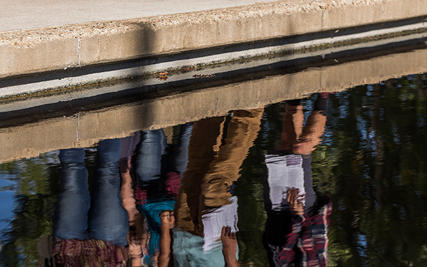 students' feet reflected in water