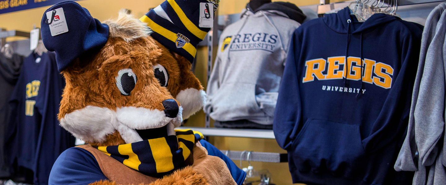 Regi the fox tries on hats and scarf in the bookstore