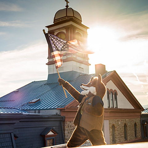 regi waving flag in front of main hall