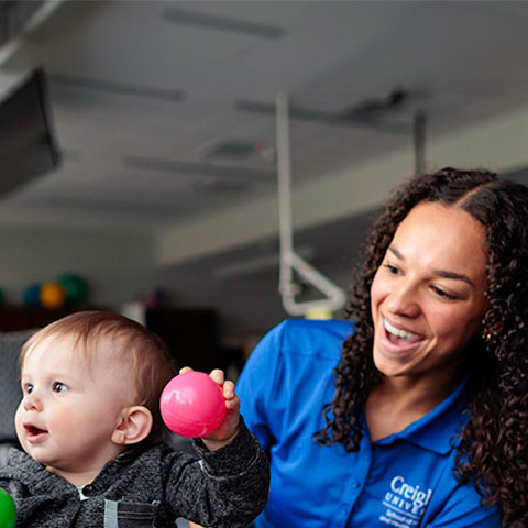 an Regis-Creighton occupational therapy student works with a toddler and mom in the occupational therapy lab