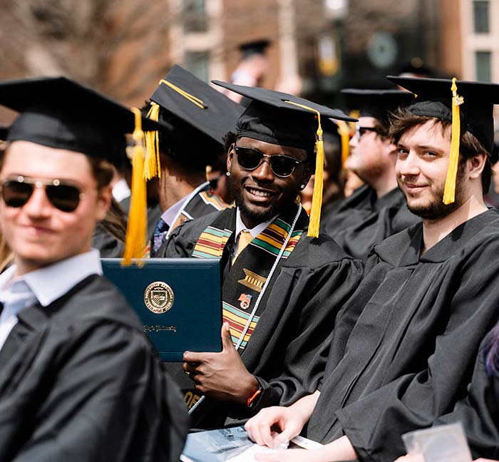 Regis University graduate cheesing and he crosses the finish line