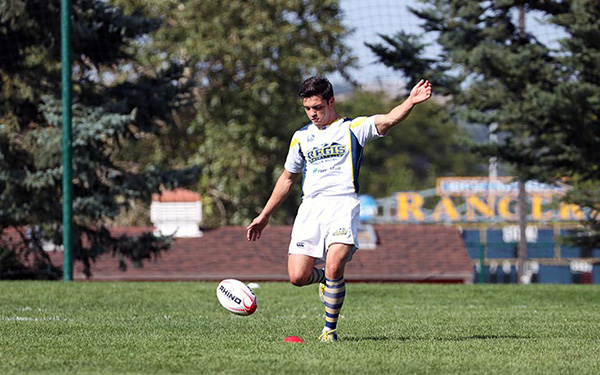 men's rugby player kicks rugby ball