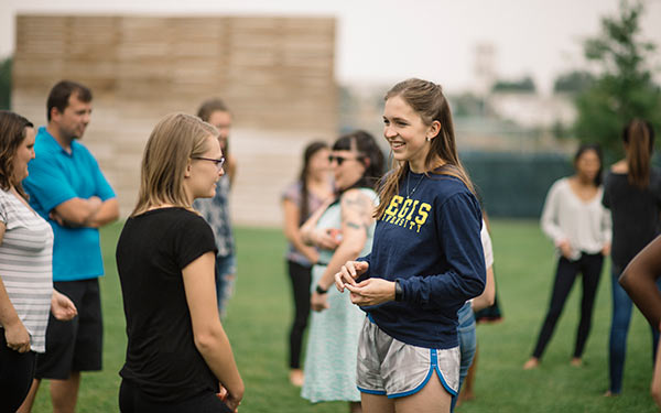 Regis students meeting at a campus event