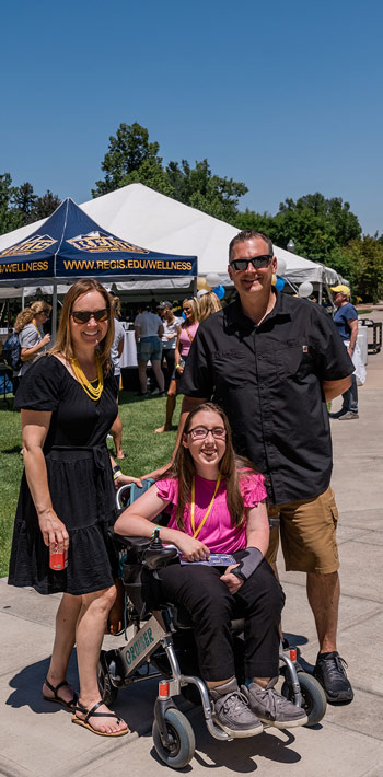 A family attending a New Student Orientation event, engaging with campus staff or faculty