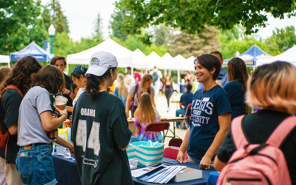 students gather at tables to talk to reps at the annual resource fair on the Quad