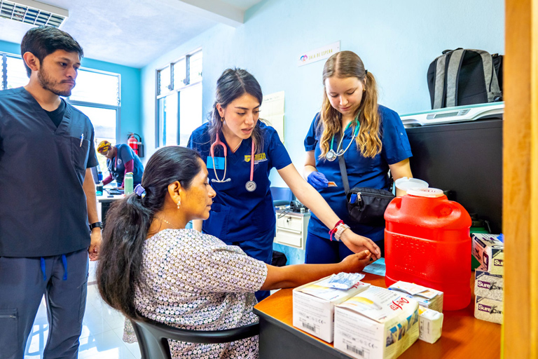 Healthcare students providing care to a patient during a global clinical experience in Guatemala