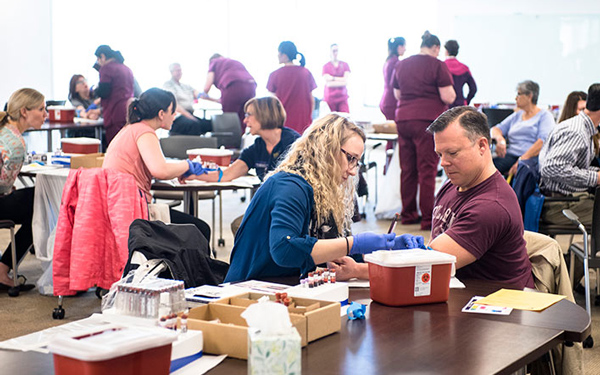 Student practicing phlebotomy skills by drawing blood during a healthcare training session