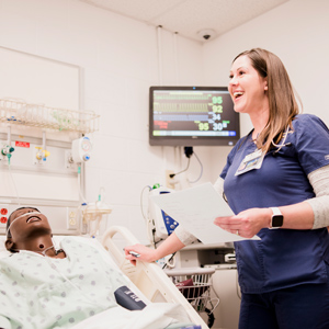 Nursing student practicing clinical skills with a patient simulator in a healthcare training lab