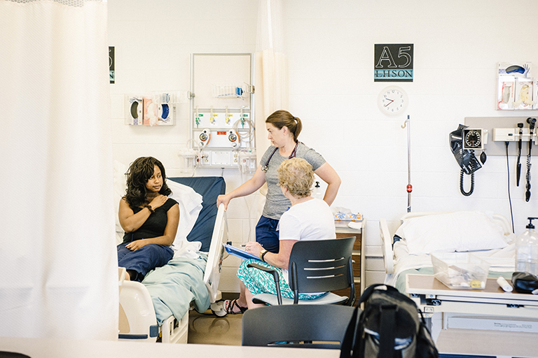 nursing student talking to instructor and patient