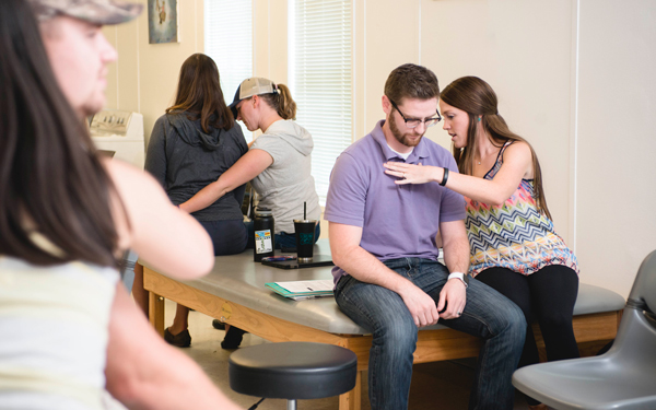 Students practicing rehabilitative assessment and treatment techniques on peers during training