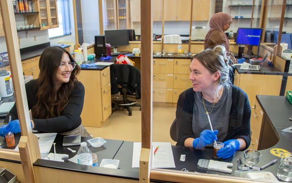 Pharmacy students preparing and mixing compounds during a lab class