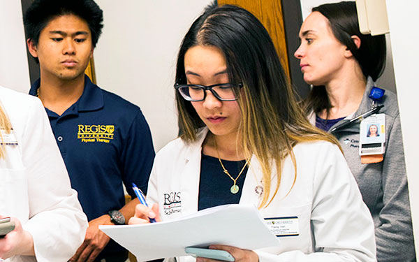Students in physical therapy, pharmacy, nursing and health services administration confer during a class at the Interprofessional Health Site in Thornton