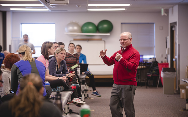 Physical therapy teacher lectures a room of students