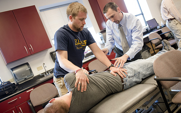 physical therapy student adjusts a patient