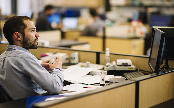 pharmacy student in professional attire sits at a desk in an office