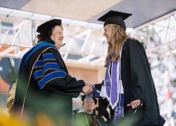 Student crossing the finish line at Regis University commencement