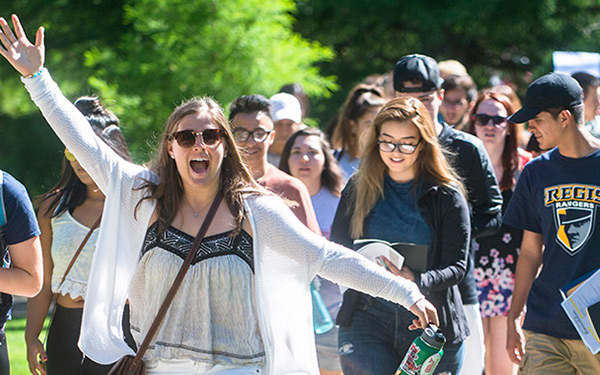 a large group of First Year Experience students walk across campus during their first days of classes