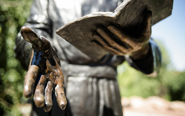 sculpture hands holding bible