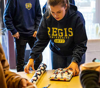 Student wrapping a gift for a campus or community donation event