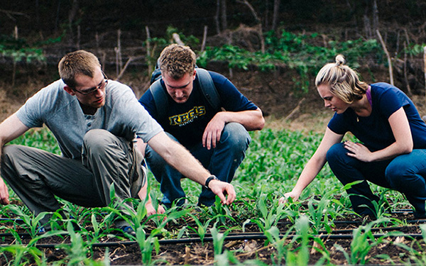 students kneeling in garden