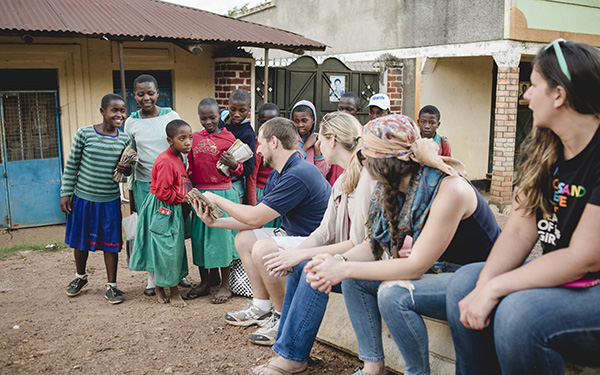 students talking with children while traveling abroad